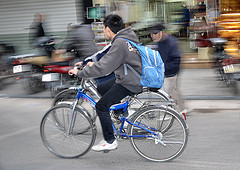 Adolescent rentrant de l'école à vélo Jeune sortant de l'école à bicyclette